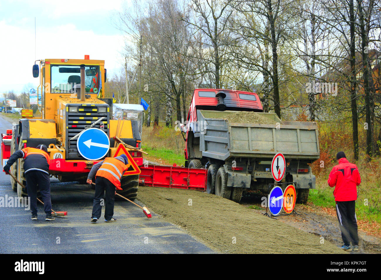 Road-rullo autocarro e team di riparazione effettuare una riparazione della strada asfaltata Foto Stock