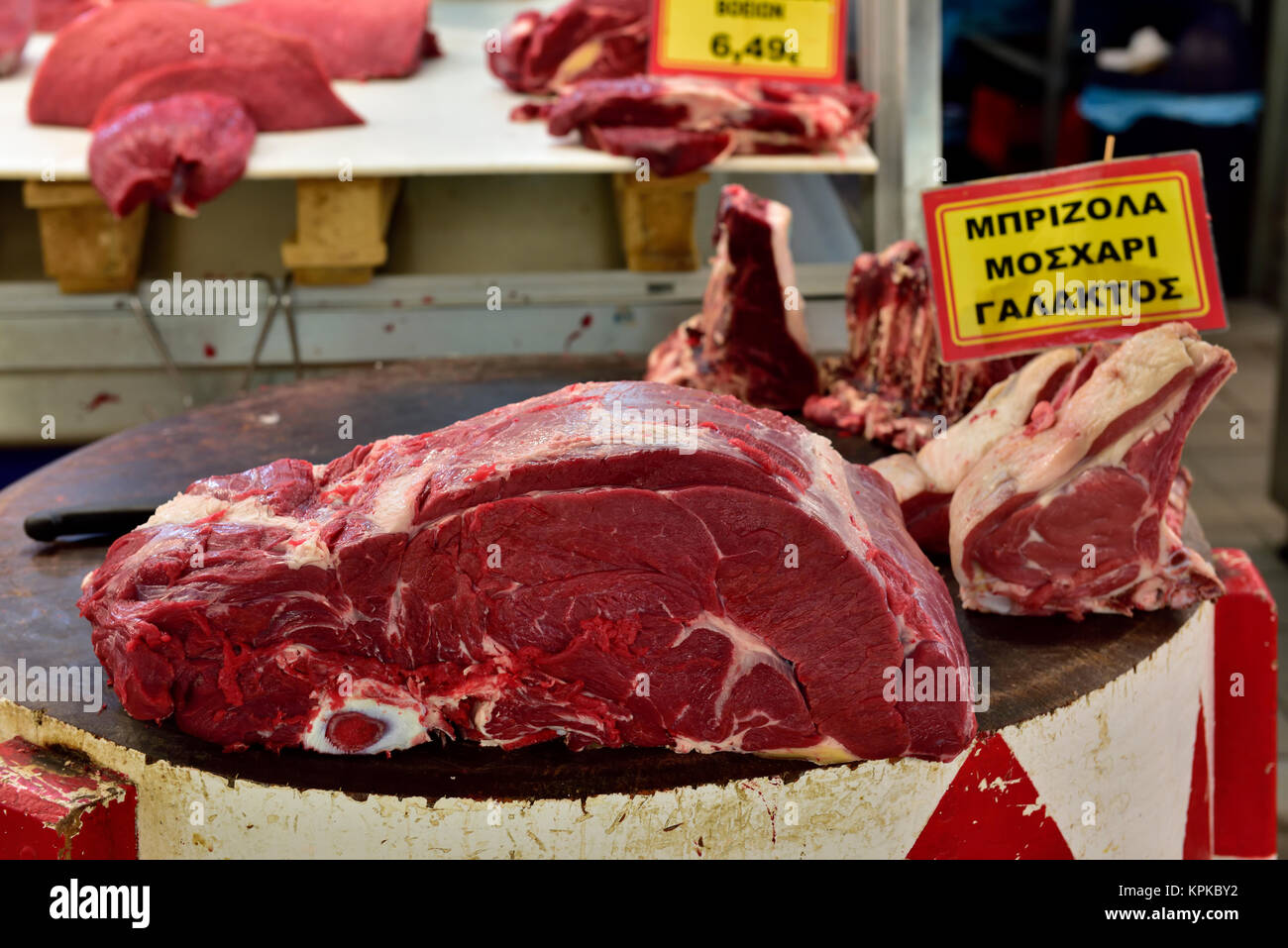 Carni macellerie sul blocco di taglio nella centrale di Atene sul mercato di carne Foto Stock