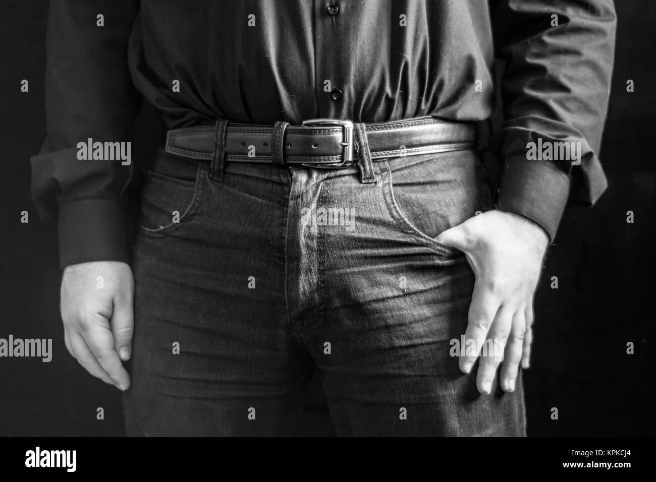 Uomo che indossa la maglia nera e jeans Foto stock - Alamy