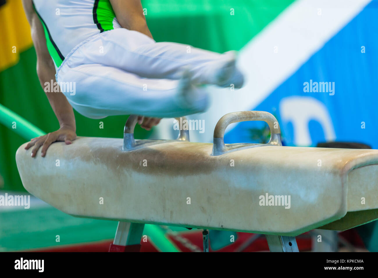 Ginnasta non identificato maschio riassunto il cavallo di velocità apparato blur azione di routine closeup photo. Foto Stock