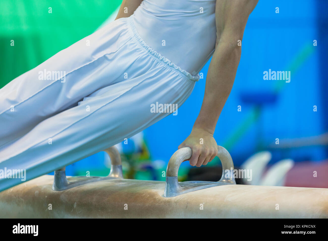 Ginnasta non identificato maschio riassunto il cavallo di velocità apparato blur azione di routine closeup photo. Foto Stock