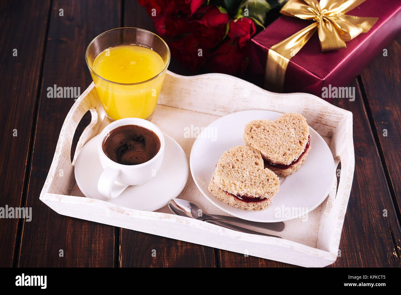 La prima colazione e la confezione regalo rossa per il giorno di San Valentino sul legno scuro tavolo. Foto Stock