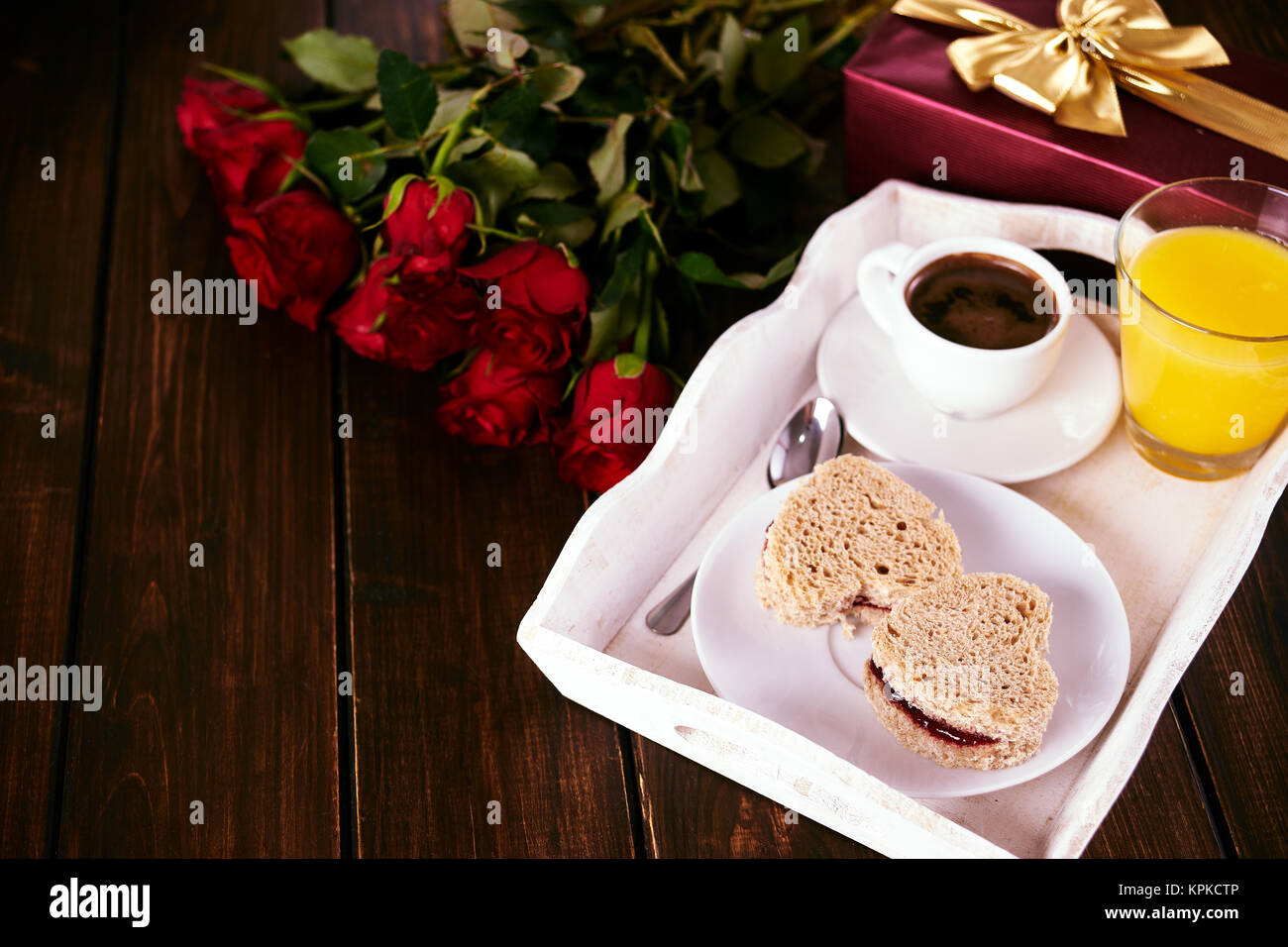 La prima colazione e la confezione regalo rossa per il giorno di San Valentino sul legno scuro tavolo. Spazio di copia Foto Stock