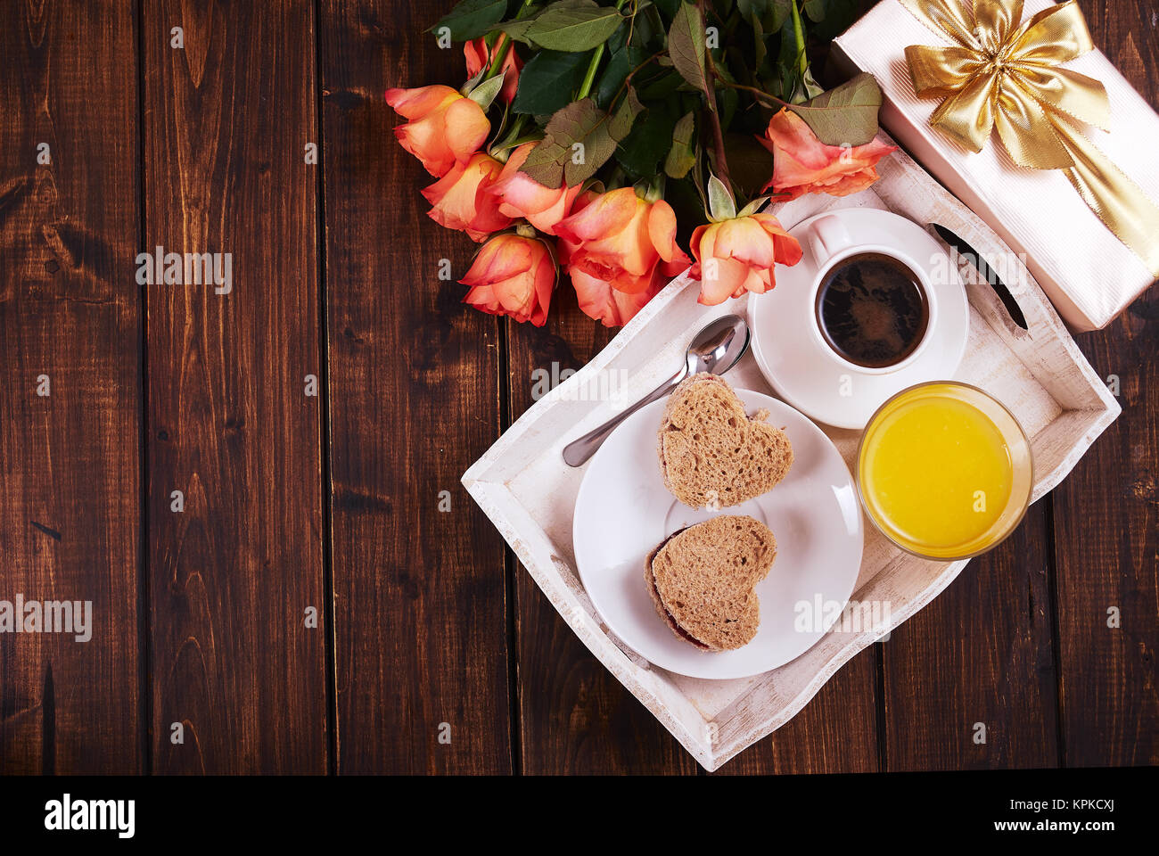 Vista superiore della prima colazione e confezione regalo con rose per San Valentino su legno scuro tavolo. Foto Stock