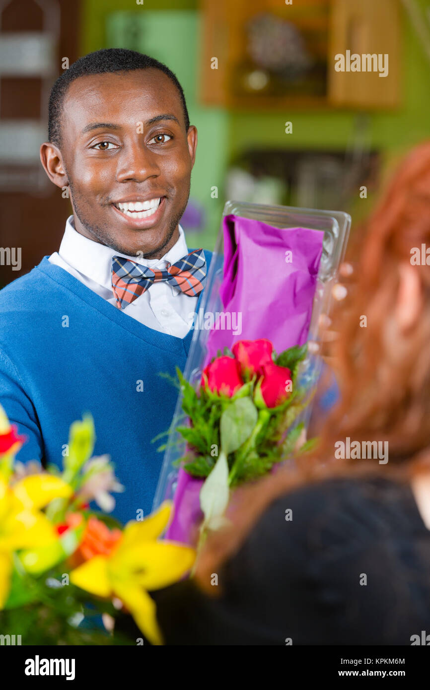 Dapper uomo nel negozio di fiori acquista le rose Foto Stock