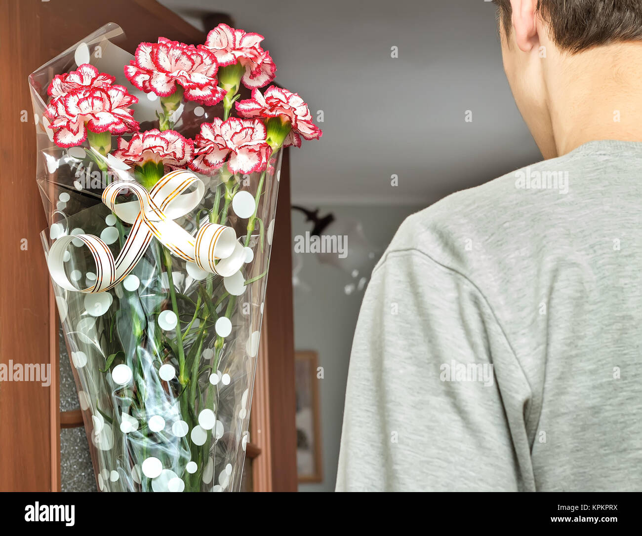 Un giovane uomo con un mazzo di fiori nelle sue mani. Foto Stock