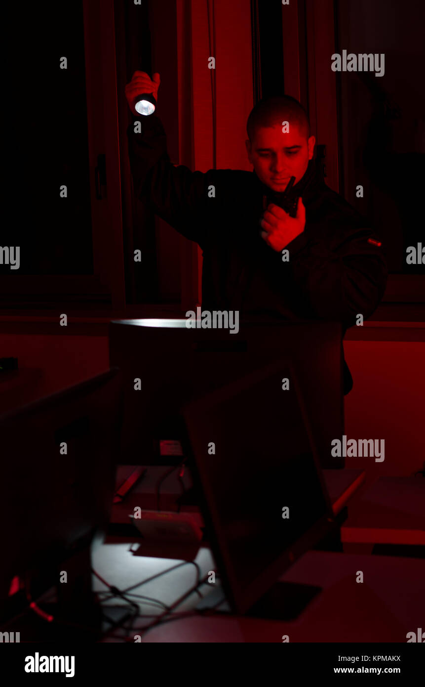 Uomo di sicurezza, controlli nel buio con la torcia elettrica Foto Stock