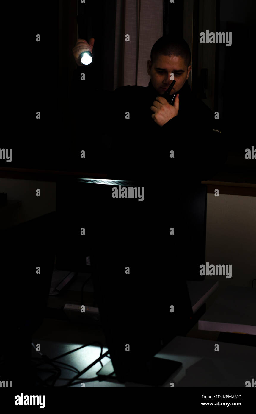 Uomo di sicurezza, controlli nel buio con la torcia elettrica Foto Stock