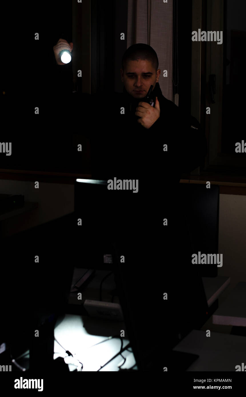 Uomo di sicurezza, controlli nel buio con la torcia elettrica Foto Stock