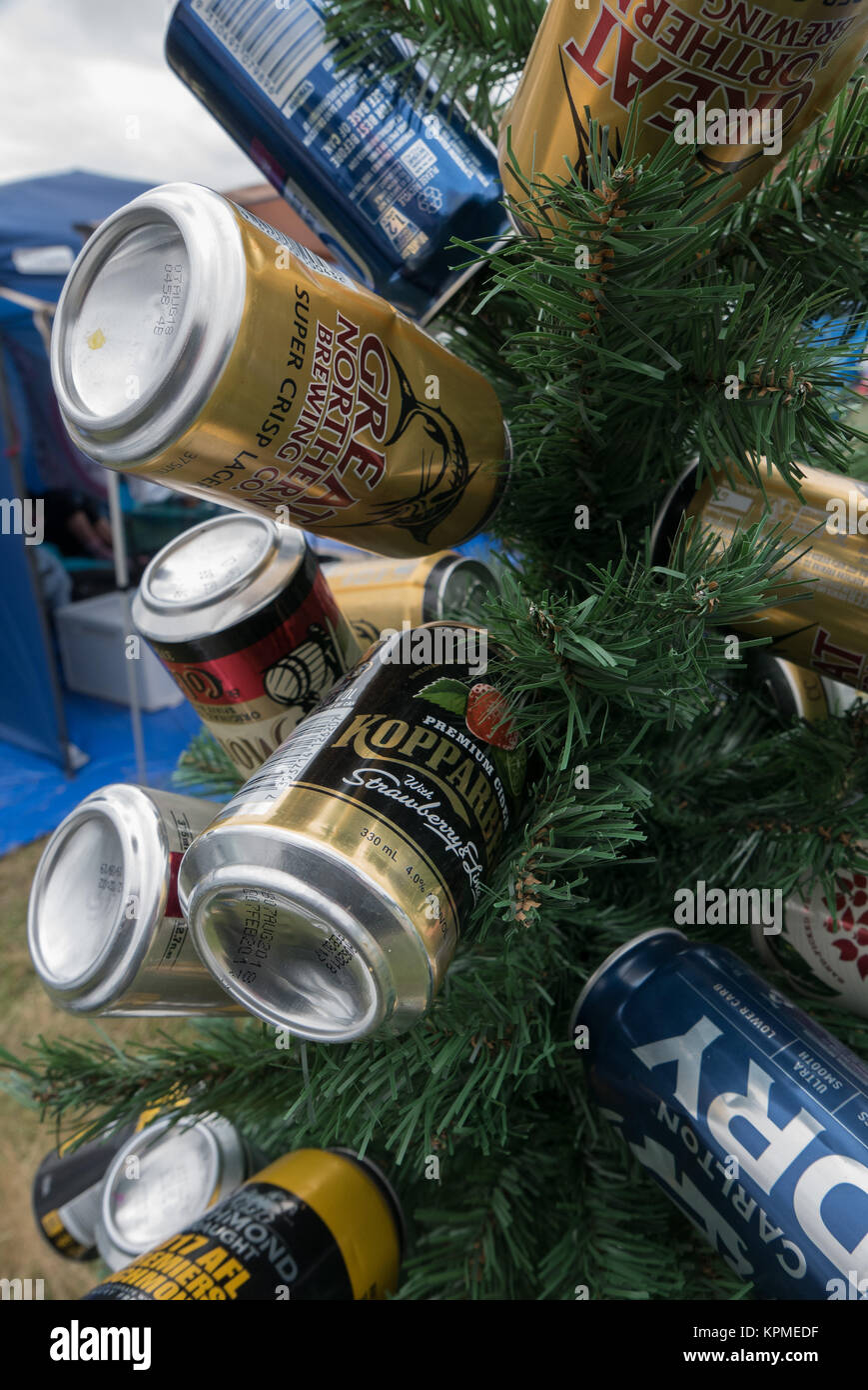 Piccolo verde albero di Natale artificiale decorato con vuoto azzurro, oro, blu e bianco della birra e sidro lattine a Meredith Music Festival. Foto Stock