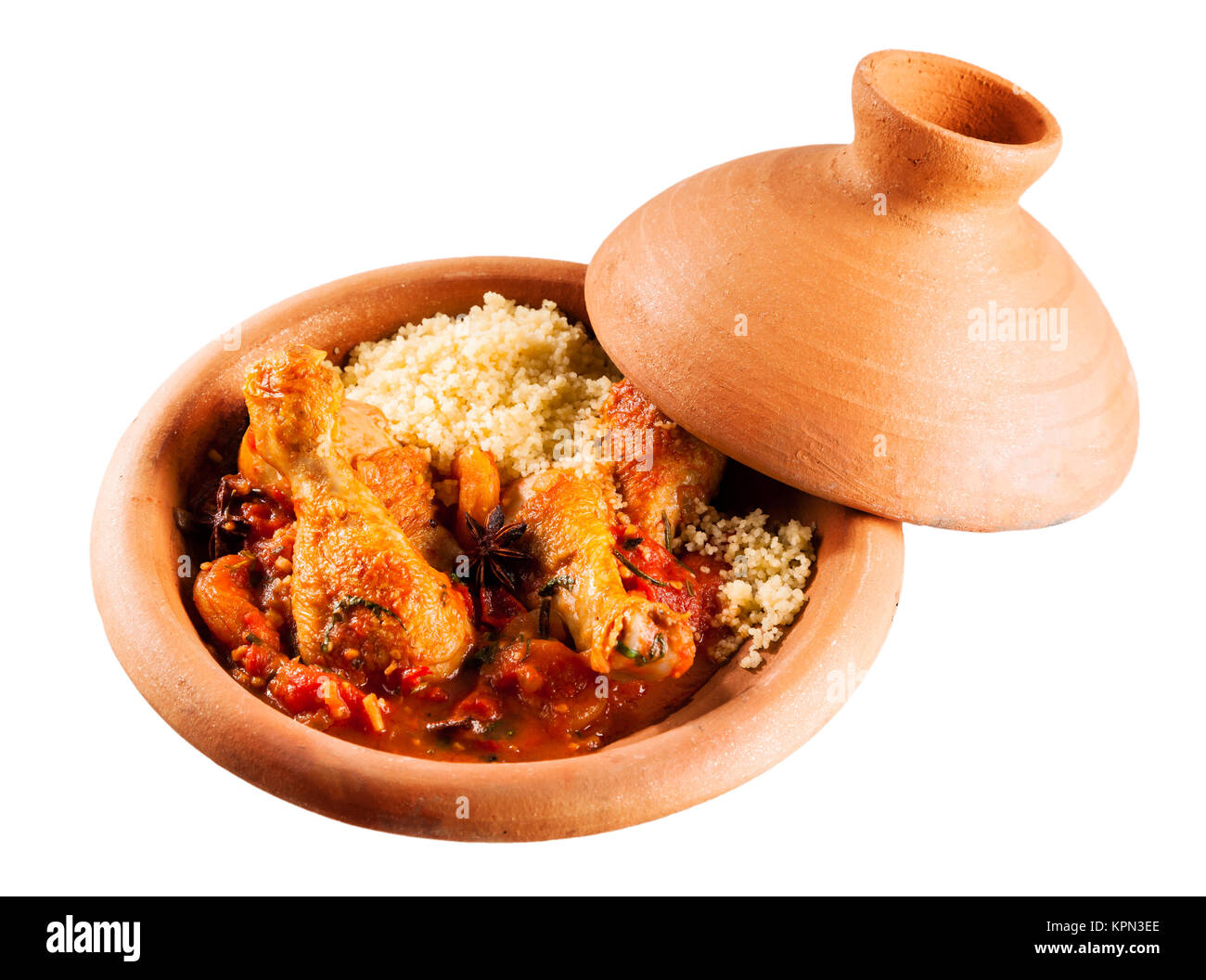 Elevato angolo di visione della tradizionale Tajine Berber piatto fatto con le cosce di pollo, couscous e saporita salsa di pomodoro servita in argilla coperto Piatto in ceramica su sfondo bianco con spazio di copia Foto Stock