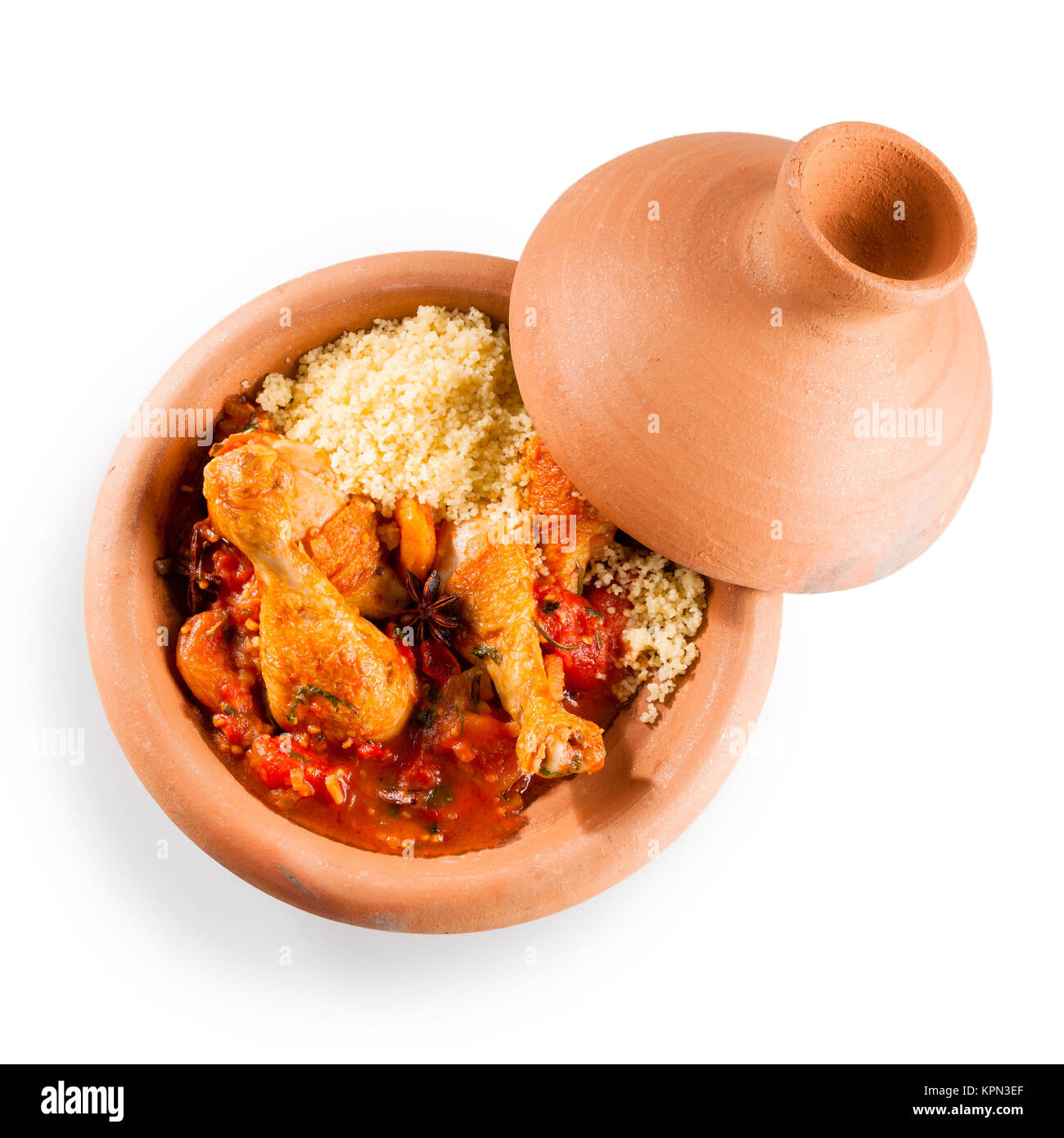 Elevato angolo di visione della tradizionale Tajine Berber piatto fatto con le cosce di pollo, couscous e saporita salsa di pomodoro servita in argilla coperto Piatto in ceramica su sfondo bianco con spazio di copia Foto Stock