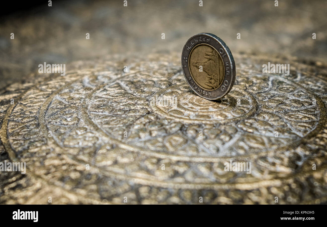 10 Thai Baht-moneta su una piastra nel tempio buddista Foto Stock