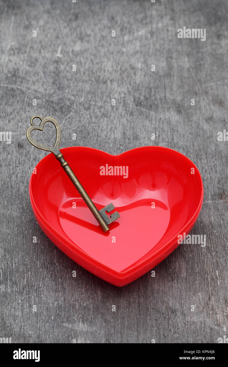 Chiave di vintage e cuore rosso su grunge sfondo di legno Foto Stock