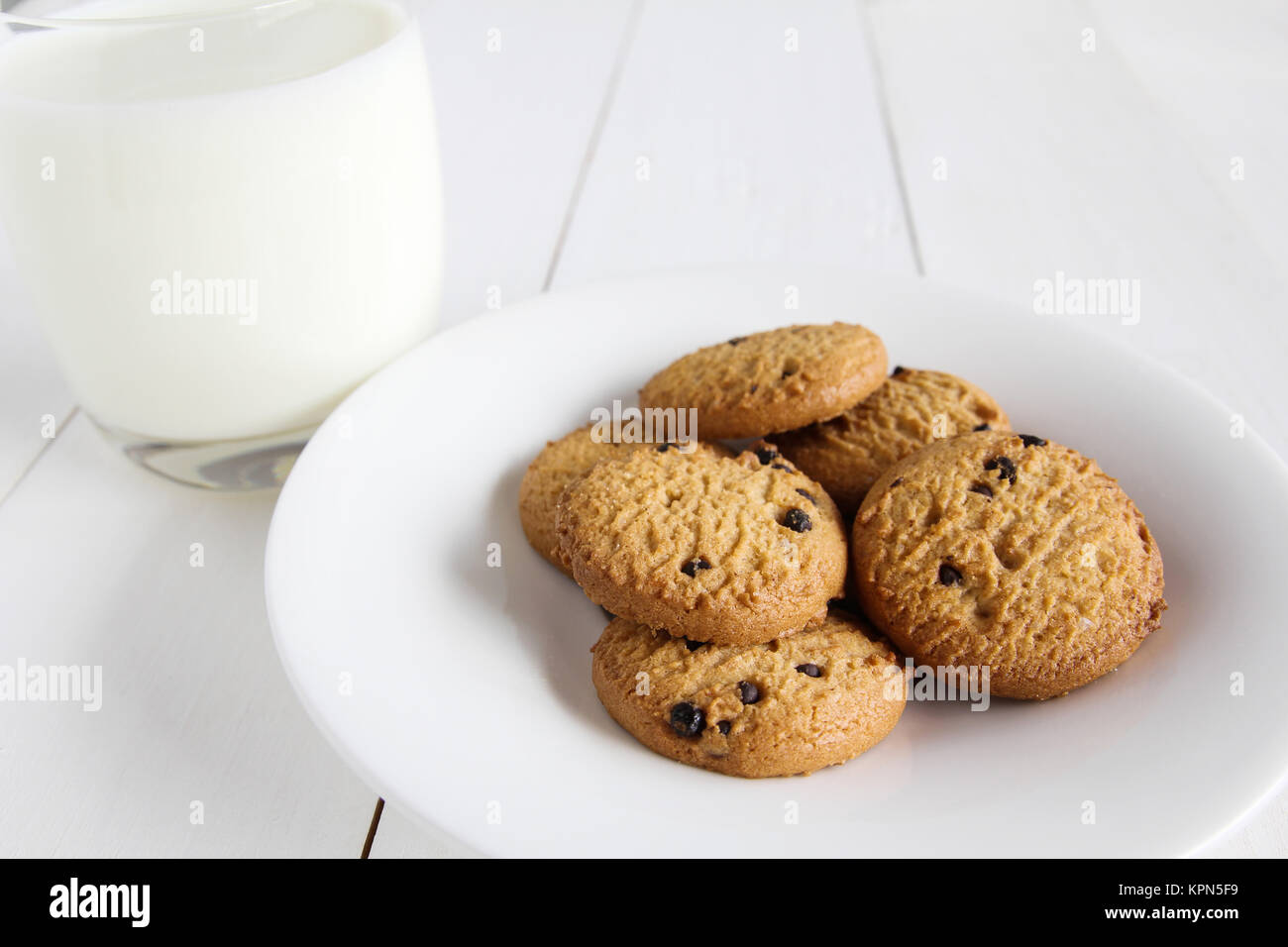 I biscotti al cioccolato con latte sul tavolo di legno. Foto Stock