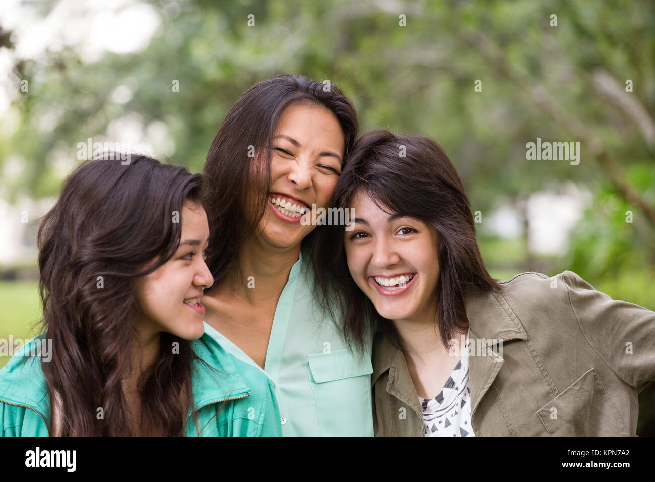 Asian madre ridendo e huging i suoi figli. Foto Stock