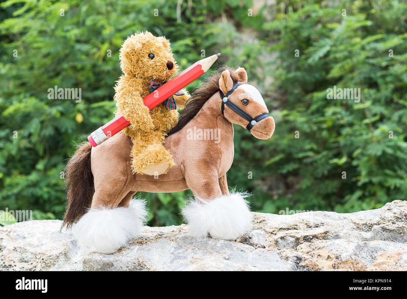 Orsacchiotto di peluche cavalcare un cavallo in foresta Foto Stock