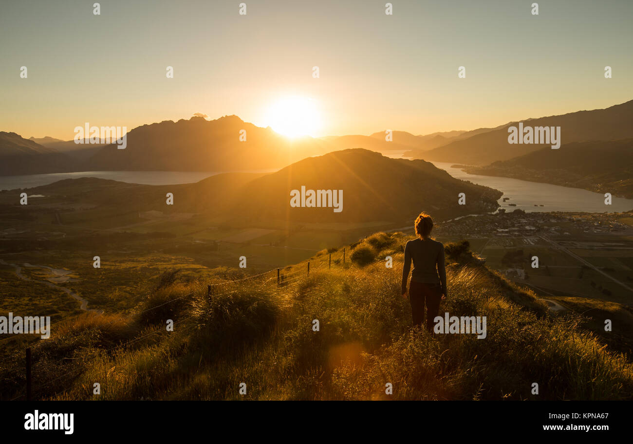 Silhouette di donna al tramonto sulla montagna Foto Stock