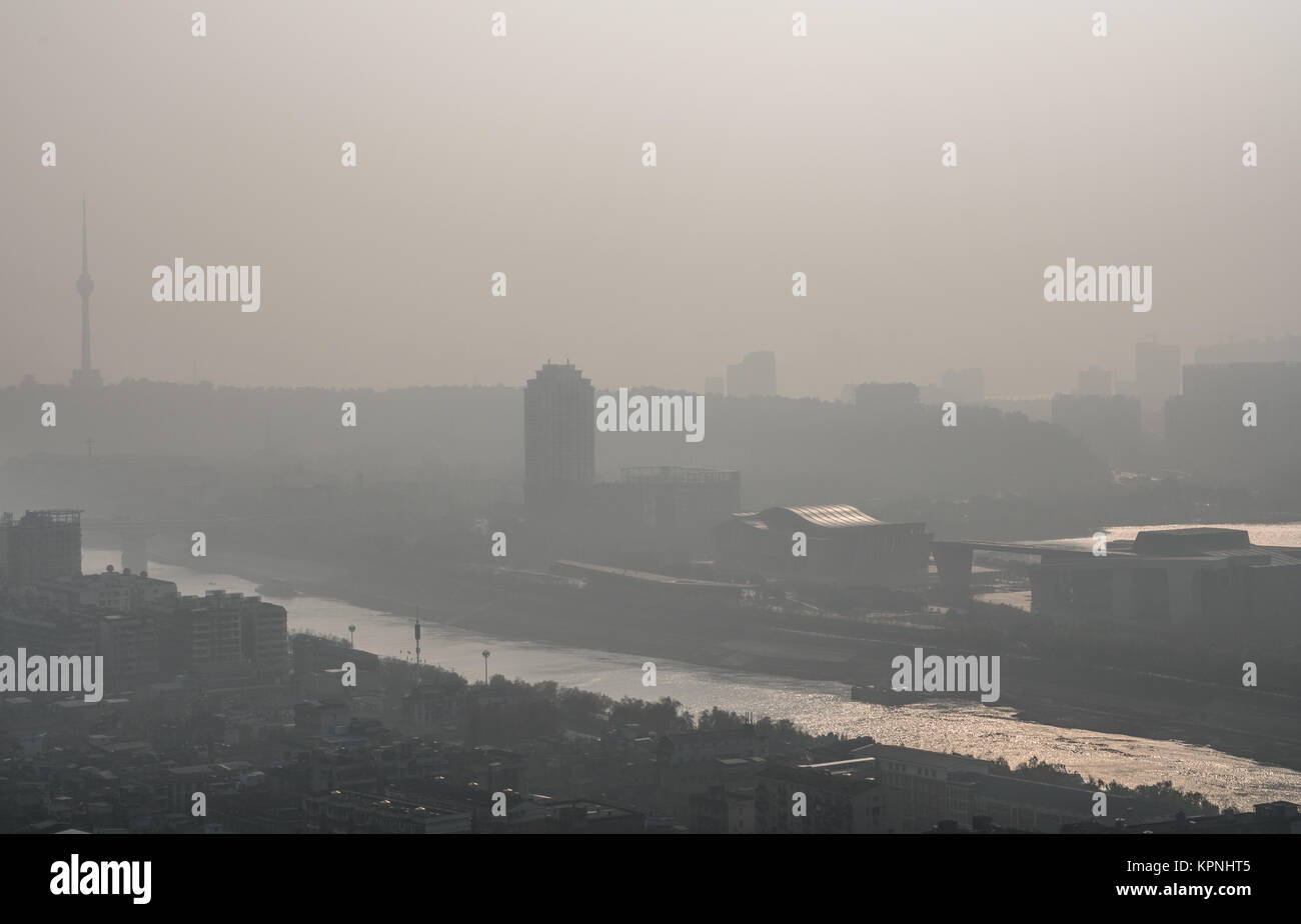 Alba sul picco di inquinamento giorno a Wuhan Cina centrale con visibile sporco haze in aria con vista della montagna di tartaruga e del fiume Han Foto Stock