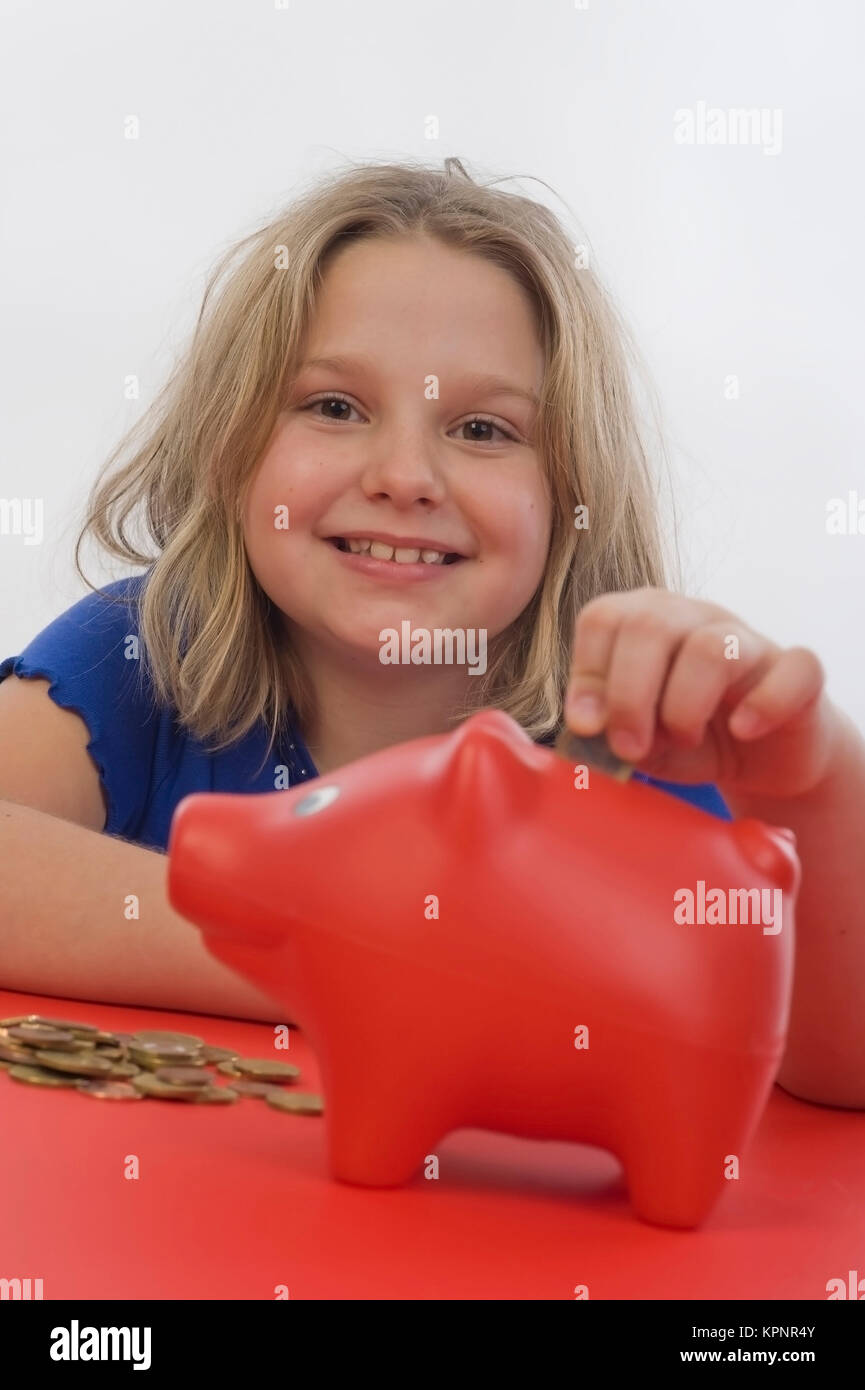 Modello di rilascio , Maedchen, 8 Jahre, fuettert Sparschwein - ragazza con salvadanaio Foto Stock