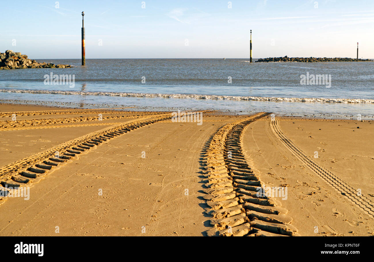 Il trattore e il rimorchio tracce di pneumatici nella sabbia dopo il lancio di una fascia costiera di barca da pesca in mare Palling, Norfolk, Inghilterra, Regno Unito. Foto Stock