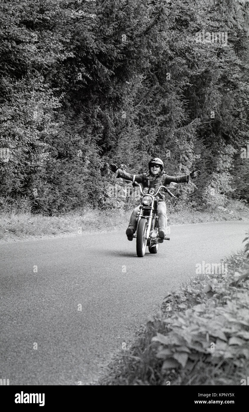 Biker con bracci outstretced su un vicolo del paese in Berkshire. Scene della Harley Davidson rally nella motivazione della Littlecote House, Berkshire, Inghilterra ion 30 settembre 1989. Il rally è stato ospitato da Pietro de Savary che possedeva la casa in quel momento. Foto Stock