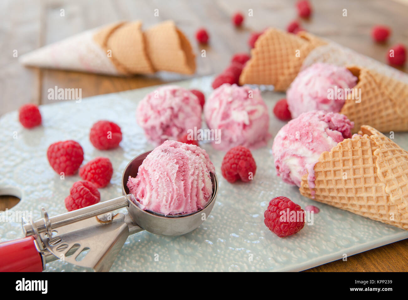 Verschiedene Kugeln Himbeereis und Eiswaffeln Foto Stock