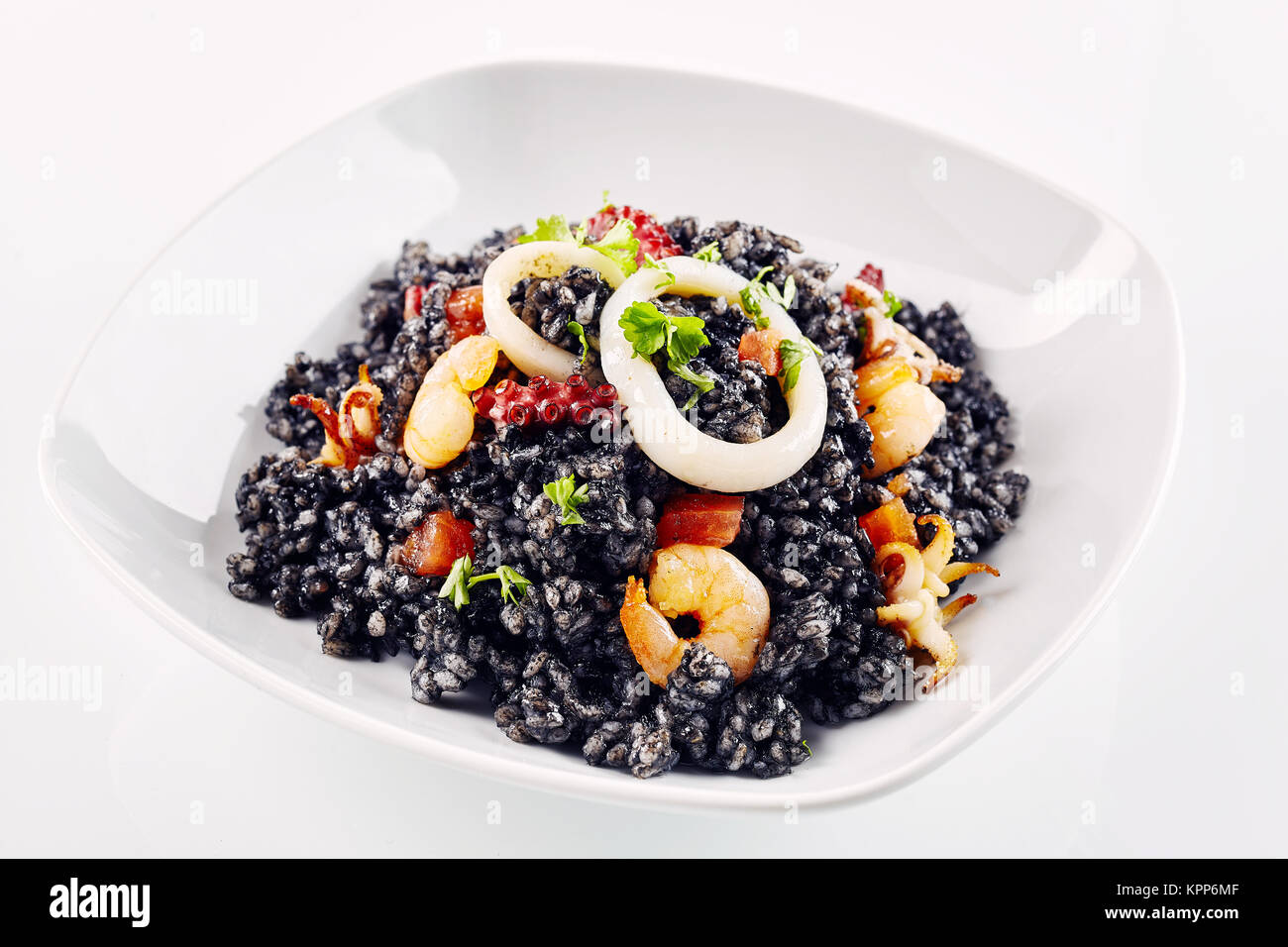 Chiusura del preparato di fresco arroz negro guarnita con vari tipi di  piatti a base di frutti di mare nel piatto bianco Foto stock - Alamy