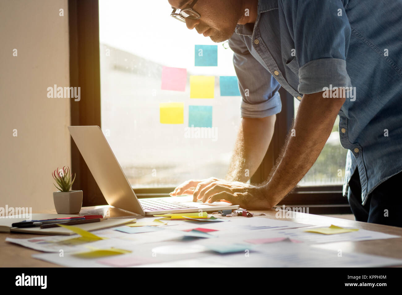 Il collegamento e il concetto di tecnologia, l'uomo utilizza computer portatile in ufficio con grafico carta business e piallatura e lavoro sulla scrivania Foto Stock