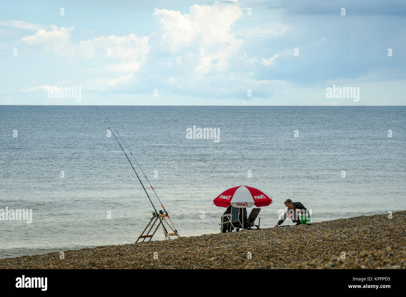 La gente seduta la pesca sulla spiaggia. Aldeburgh English città costiera nel Suffolk, Regno Unito Foto Stock