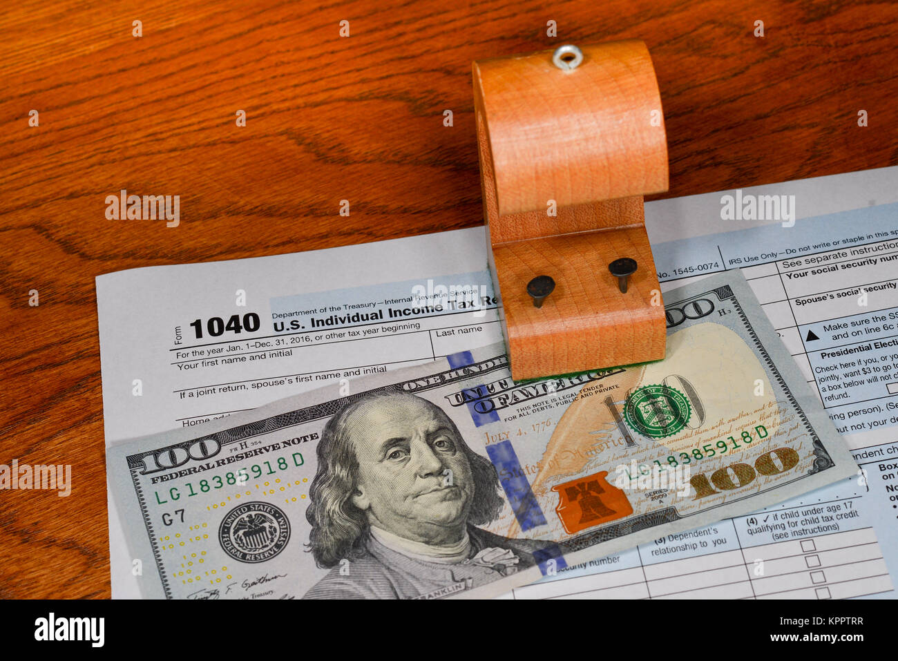 A noi il reddito individuale forma fiscale con un $100 bill e una tassa di legno (tack) rifugio concetto risparmio fiscale. Foto Stock