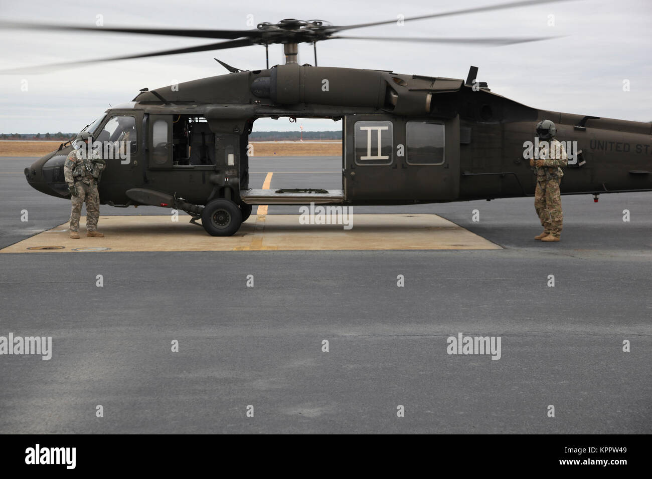 Esercito degli Stati Uniti Reserve UH-60 Blackhawk i piloti di elicottero in stand by il loro elicottero durante il ventesimo annuale di Randy Oler Memorial il funzionamento del giocattolo Drop, ospitato dalla U.S. Esercito degli affari civili e le operazioni psicologiche il comando (airborne), 6 Dicembre 2017 a MacKall Army Airfield, North Carolina. Il funzionamento del giocattolo Drop è la più grande del mondo di combinata airborne operazione con otto partner paracadutisti nazione partecipante e soldati consente la possibilità di allenarsi sul loro militari professionali di specialità, mantenere la loro disponibilità aerea e restituire alla comunità locale. (U.S. Esercito Foto Stock