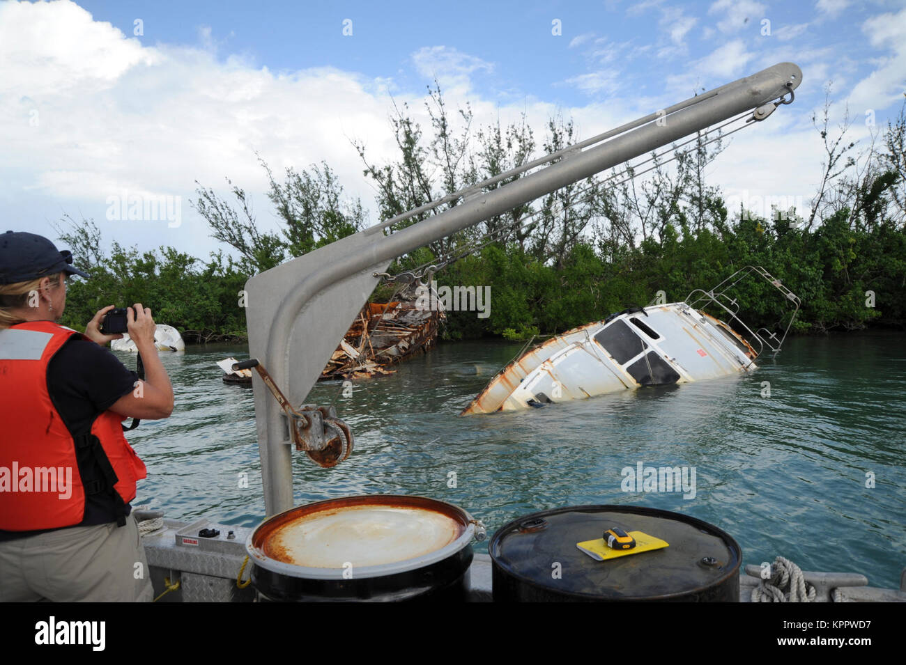 Catherine Berg della National Oceanic and Atmospheric Administration, che è parte dell'Uragano Maria FSE-10 Puerto Rico risposta, documenti di una nave elica dall uragano Maria, come lei valuta possibili preoccupazioni ambientali circostanti il salvataggio della nave, Isleta Marina, Porto Rico, 6 dicembre 2017. Il FSE-10 missione è offerta senza costi le opzioni per la rimozione di imbarcazioni elica dall uragano Maria; interessati i proprietari di imbarcazioni sono invitati a chiamare il proprietario della nave Hotline Outreach al (786) 521-3900 per l'assistenza gratuita. (U.S. Coast Guard Foto Stock