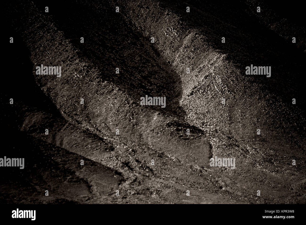 Ein dunkler Berghang aus schroffen und markanten Gesteinsformationen. Foto Stock