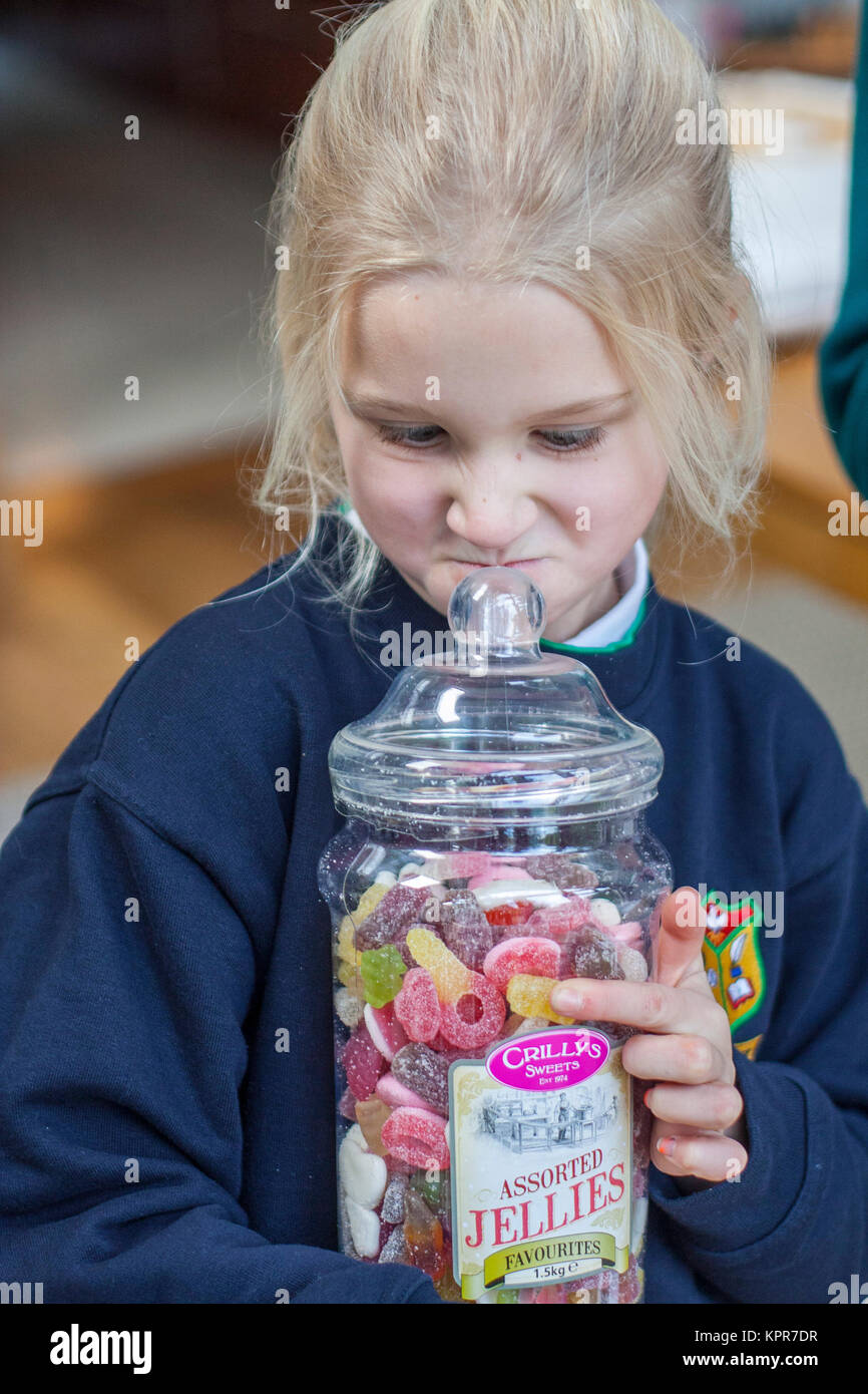 Bambino tenendo un grande vaso in plastica assortiti di gelatine Foto Stock