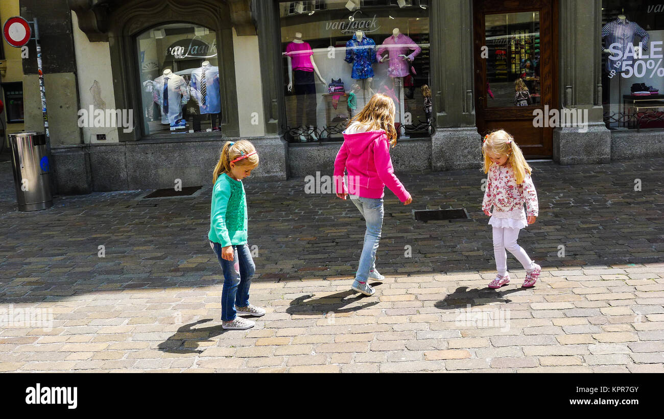 Bambini inseguono le loro ombre Lucerna Svizzera, estati soleggiate giorno, bambine ombra il concetto di infanzia, dolce innocente stupiti discovery learning Foto Stock