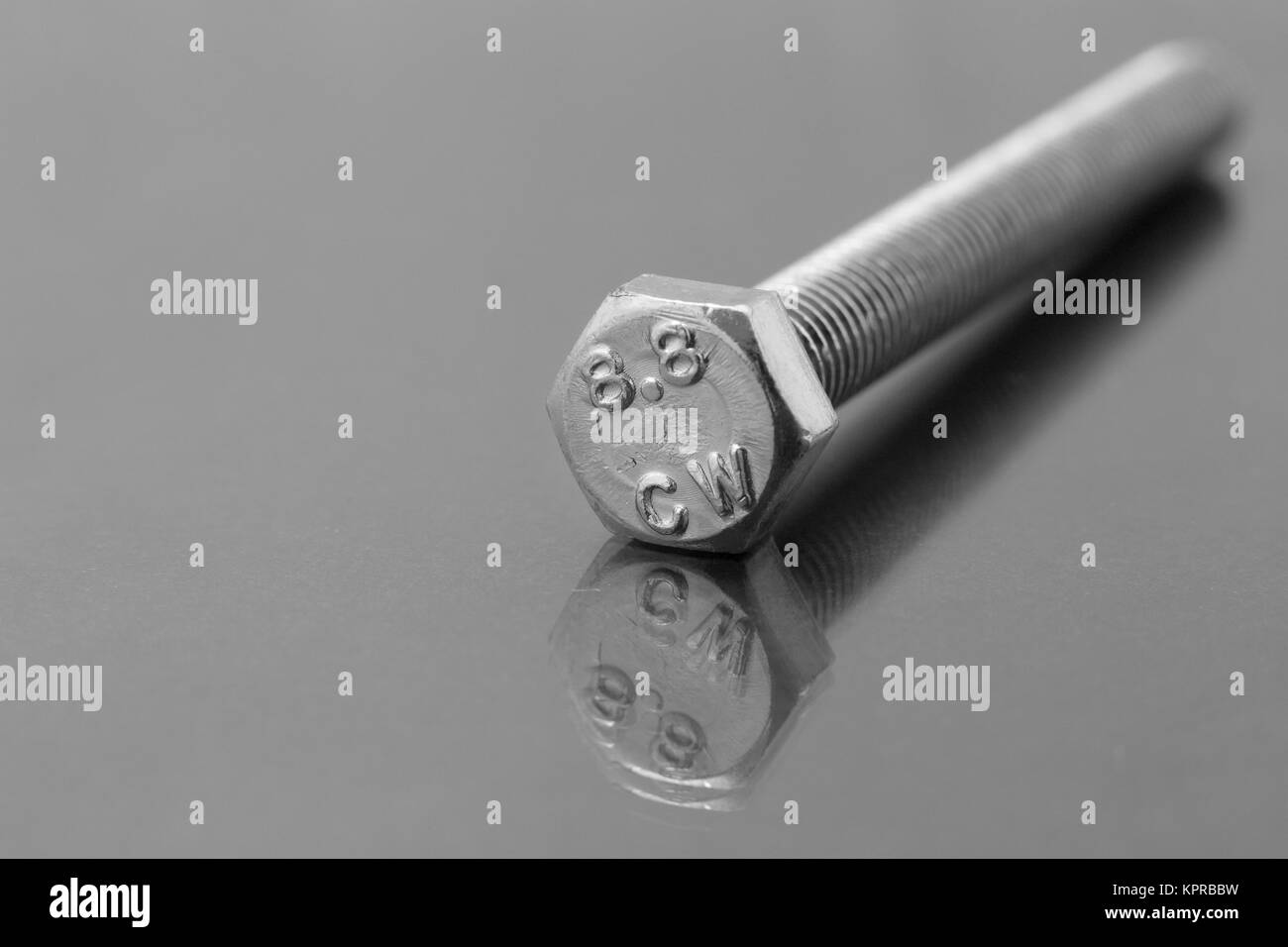 Close up di un bullone isolato su un piano riflettente Foto Stock