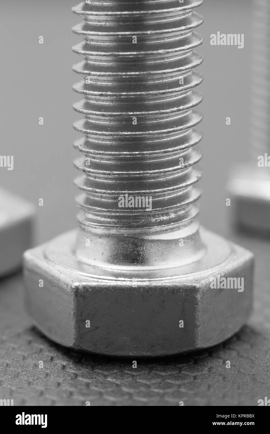 Primo piano di un bullone su sfondo grigio Foto Stock