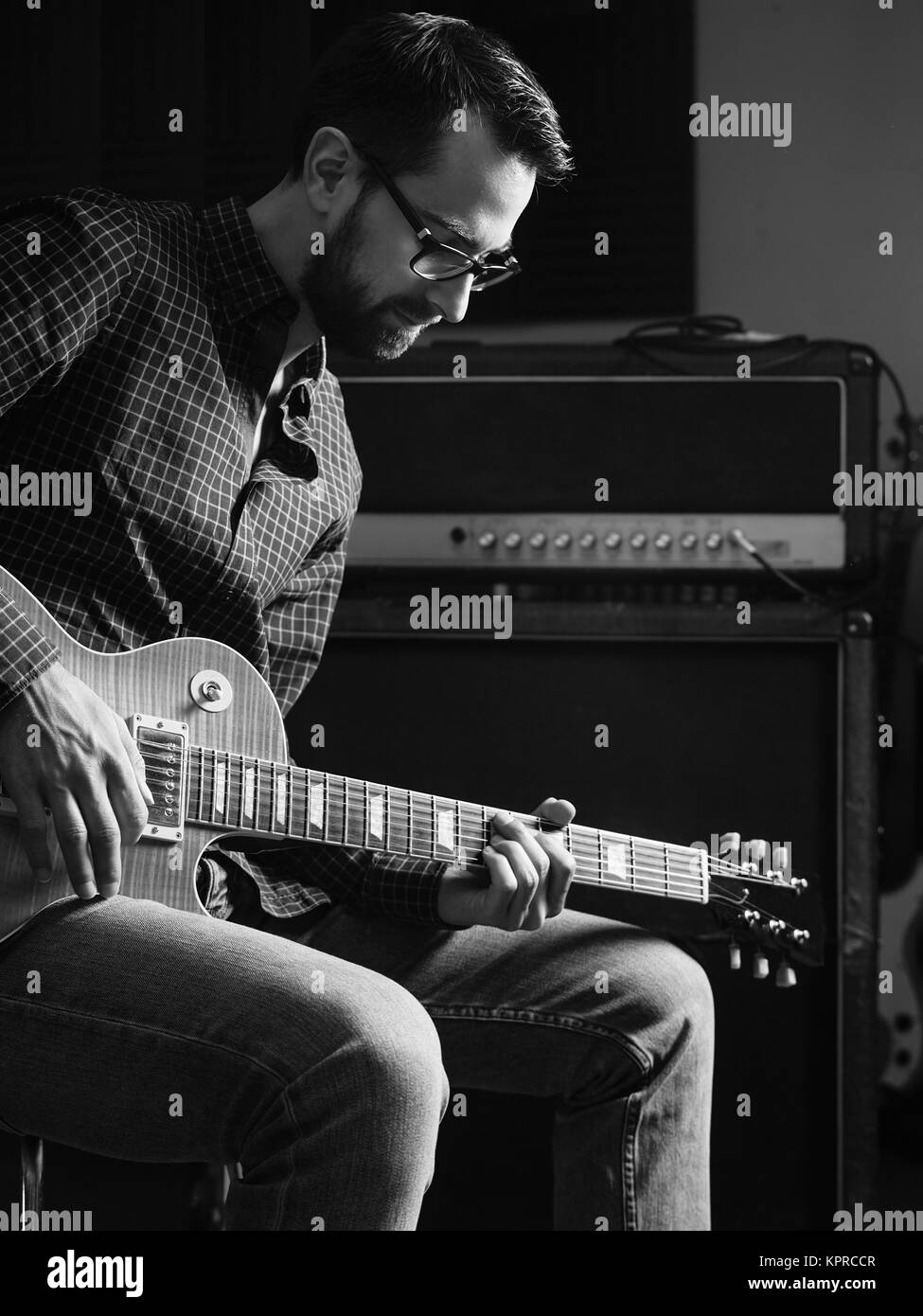 Concentrandosi sulla sua chitarra elettrica la riproduzione Foto Stock