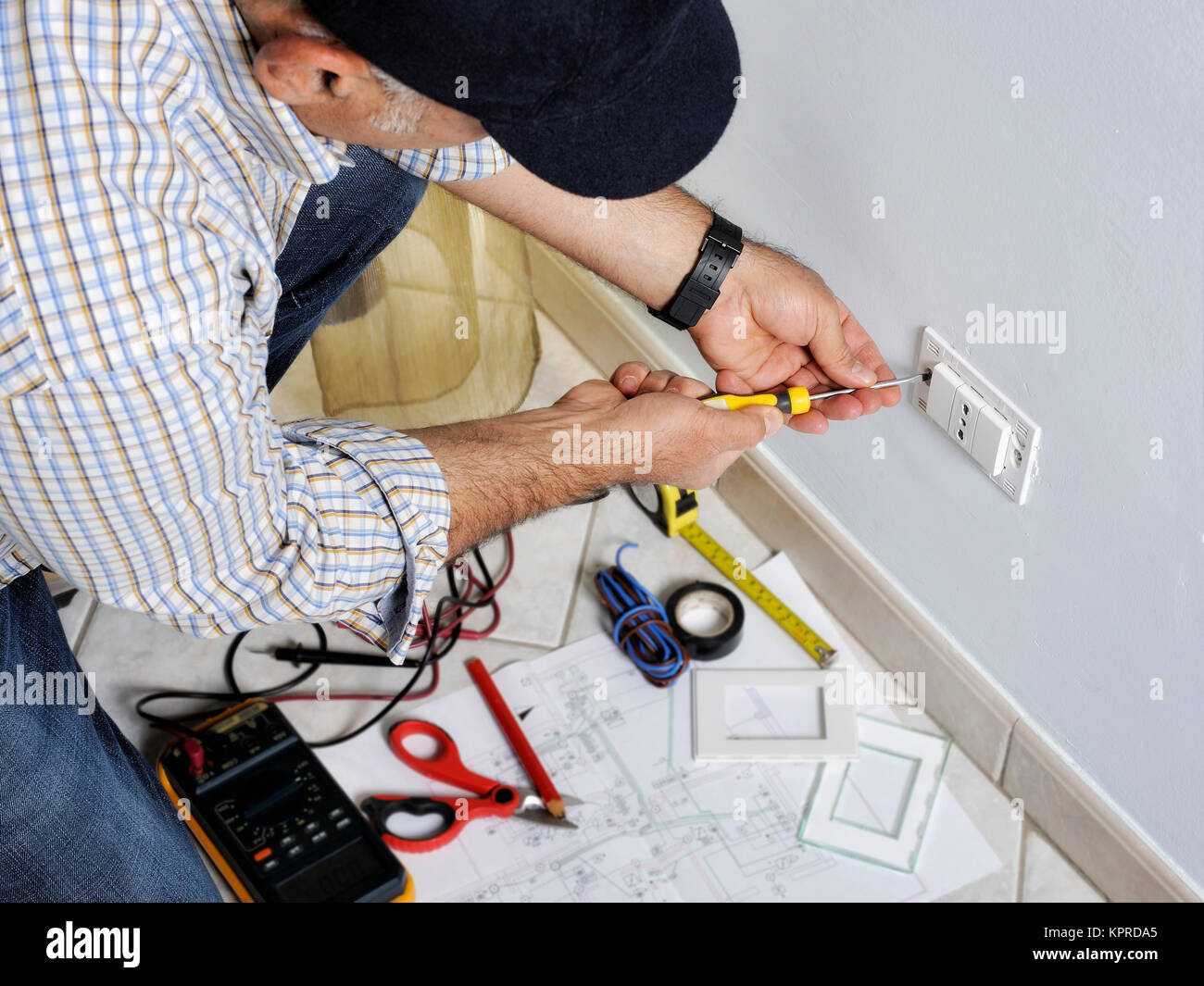 Elettricista tecnico al lavoro utilizza la pinza spelafili in una zona  residenziale di installazione elettrica Foto stock - Alamy
