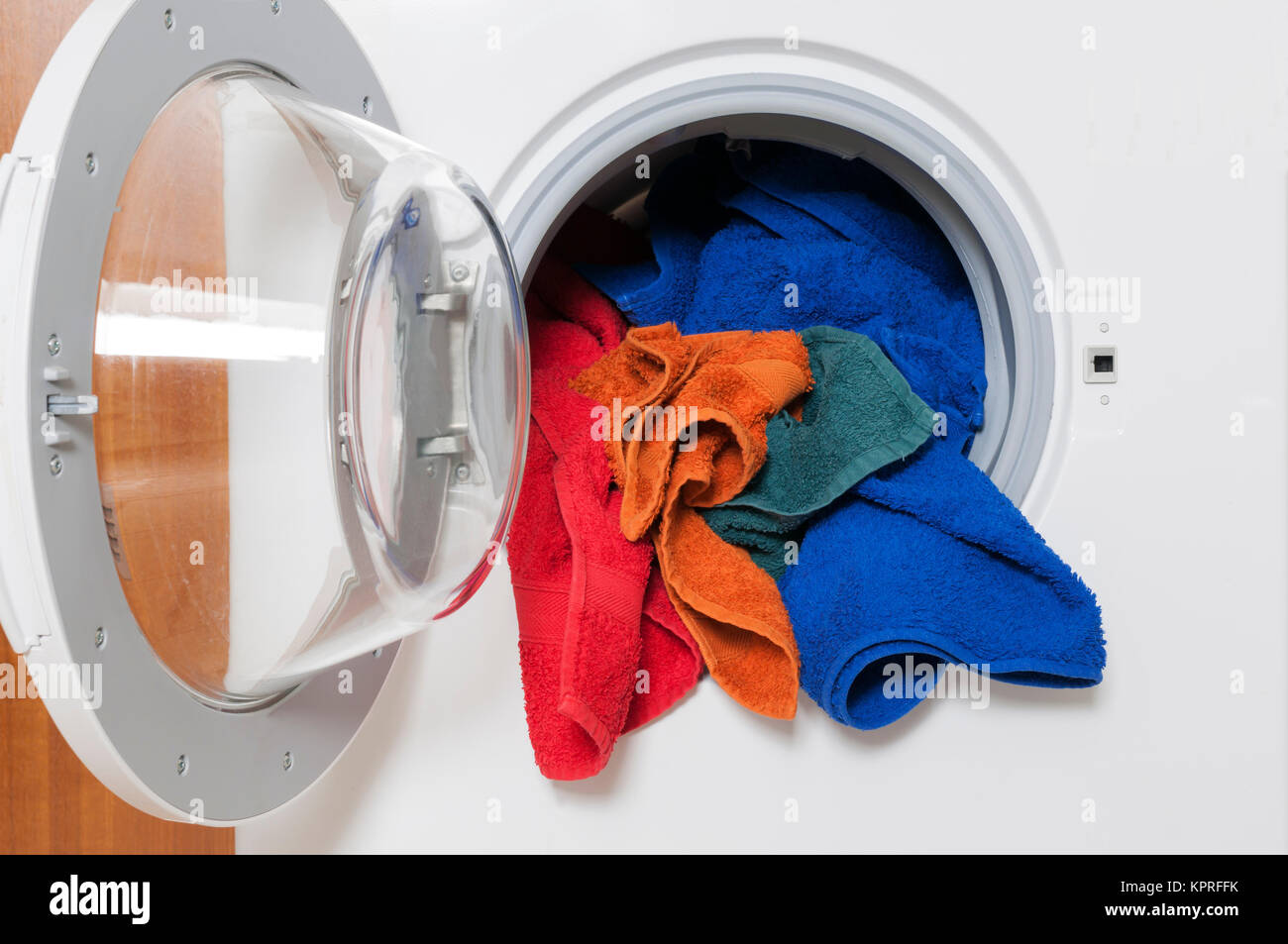 Hausarbeit, Waschservice, Waschmaschine mit bunter Waesche. Foto Stock