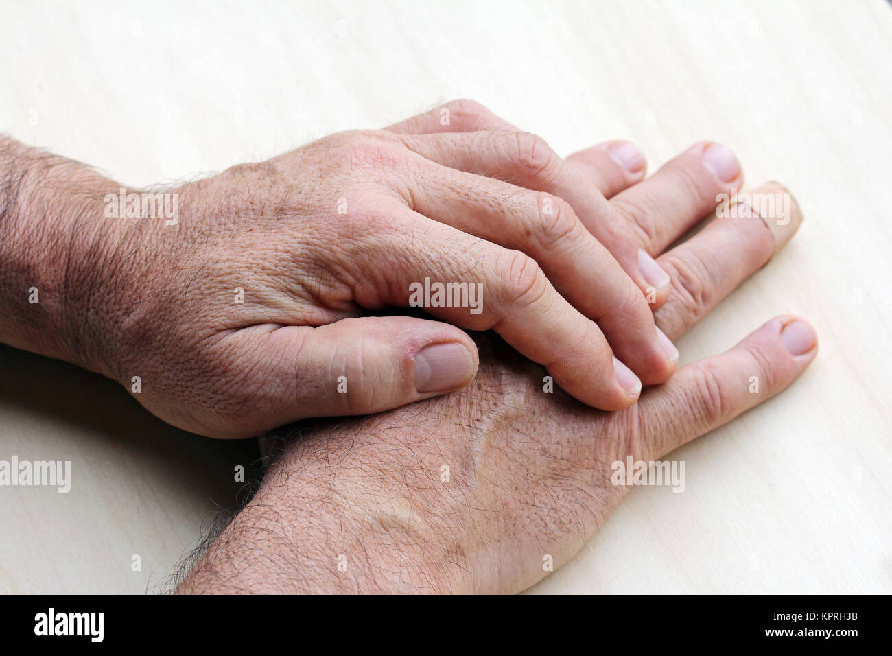 Un uomo anziano ha il dolore in le dita e le mani Foto Stock
