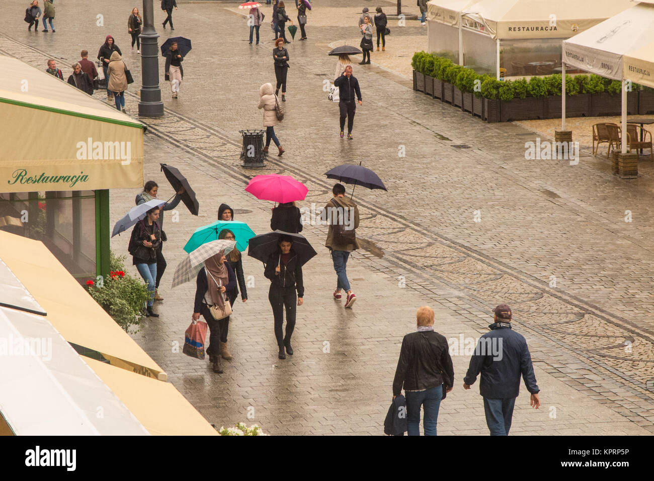 La gente camminare sotto la pioggia sotto vivacemente colorato ombrelloni / ombrelloni in piazza del mercato nella città polacca di Wroclaw Polonia Foto Stock