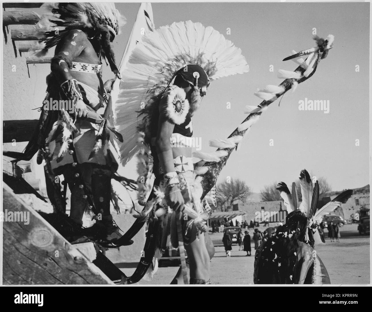 Tre indiani nel copricapo in primo piano a guardare i turisti 'Danza San Ildefonso Pueblo New Mexico 1942." 1942 Foto Stock