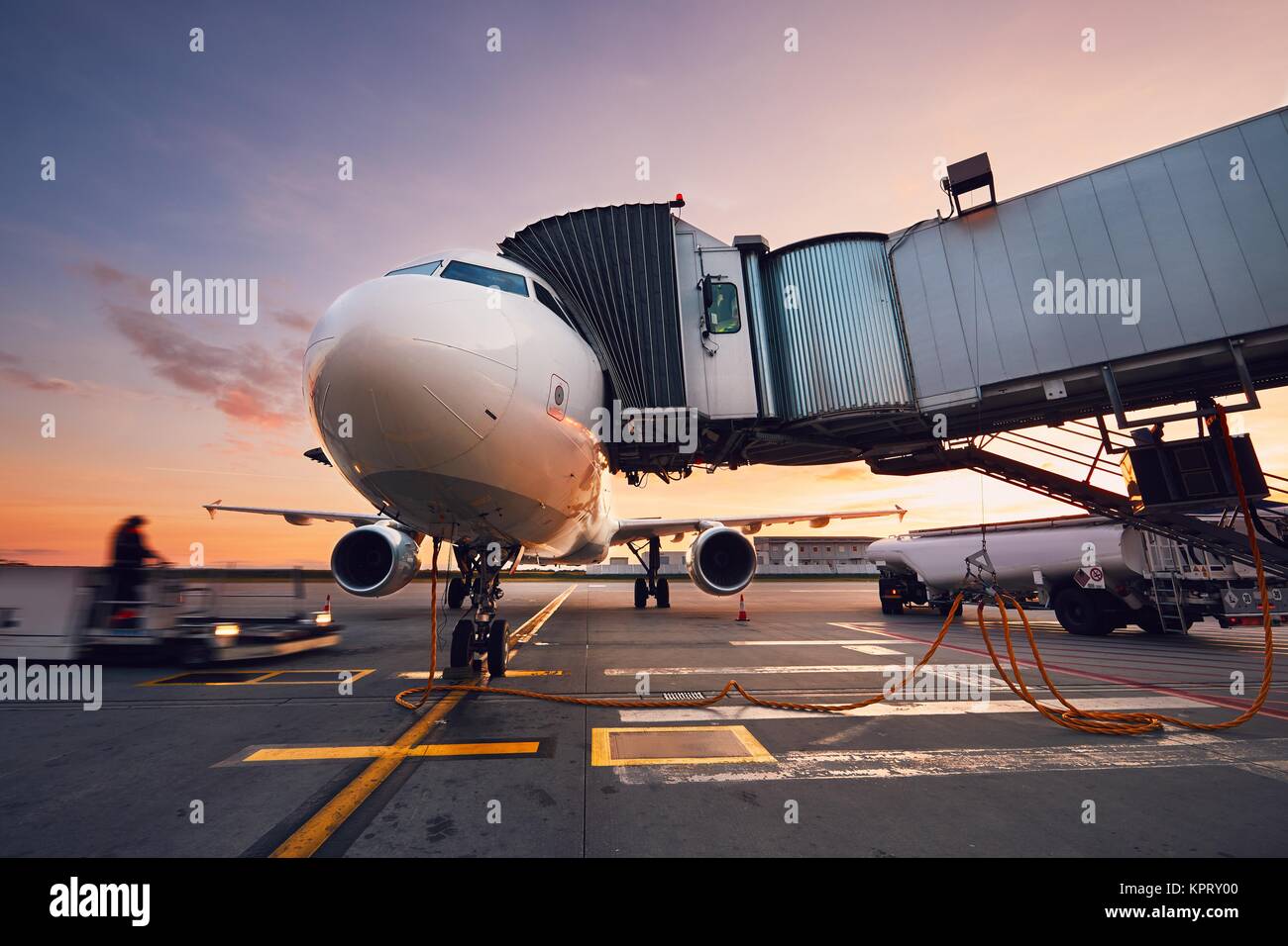 Aeroporto occupato al tramonto colorato. Preparazione del velivolo prima del volo. Foto Stock