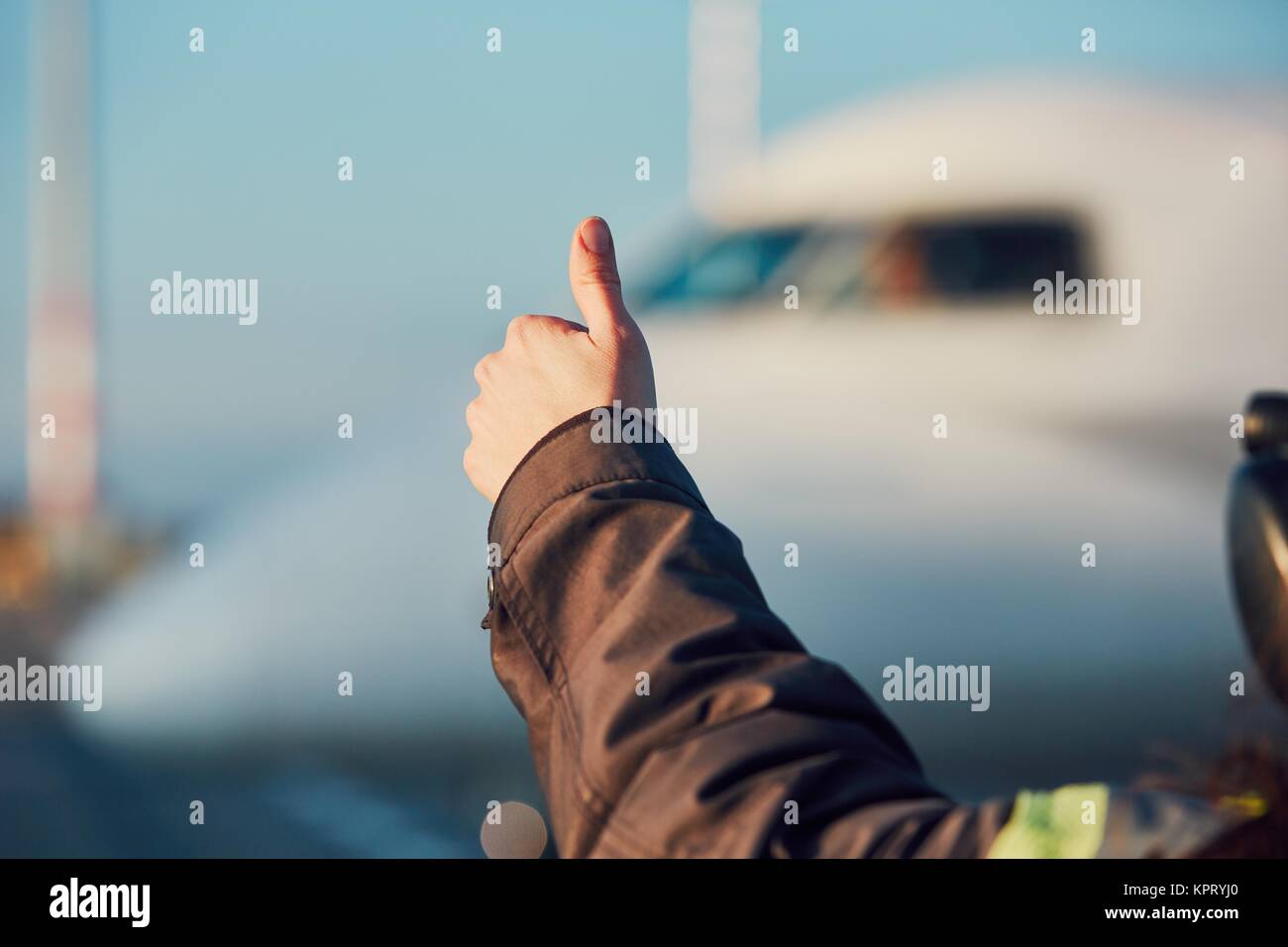 Giornata di sole in aeroporto. Membro del personale di terra è che mostra segno OK per un pilota prima del decollo. Foto Stock