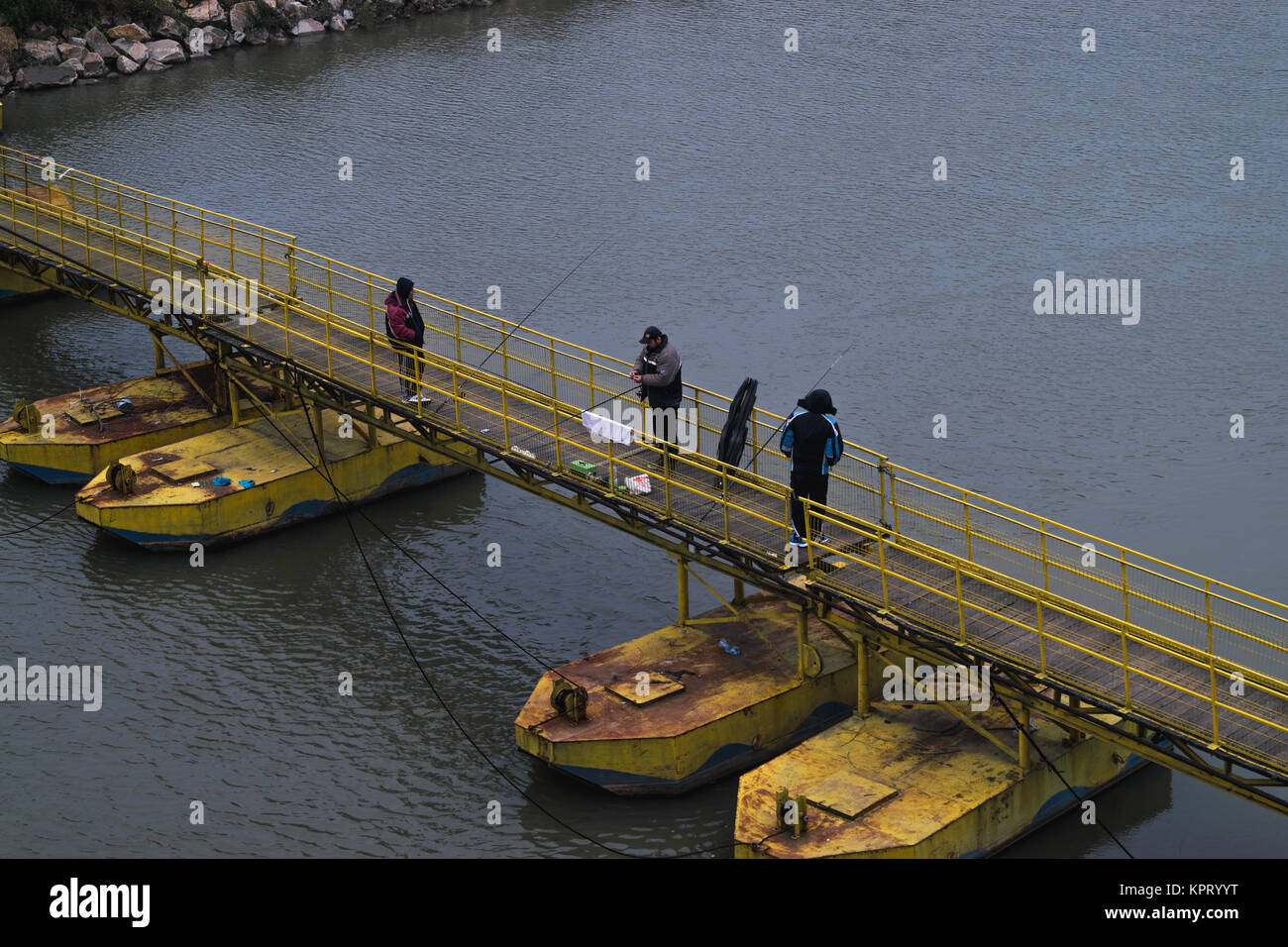 ARAD, Romania - 18 dicembre 2015: Uomini non identificati la pesca su un ponte temporaneo al di sopra di Mures river in Arad, Romania Foto Stock