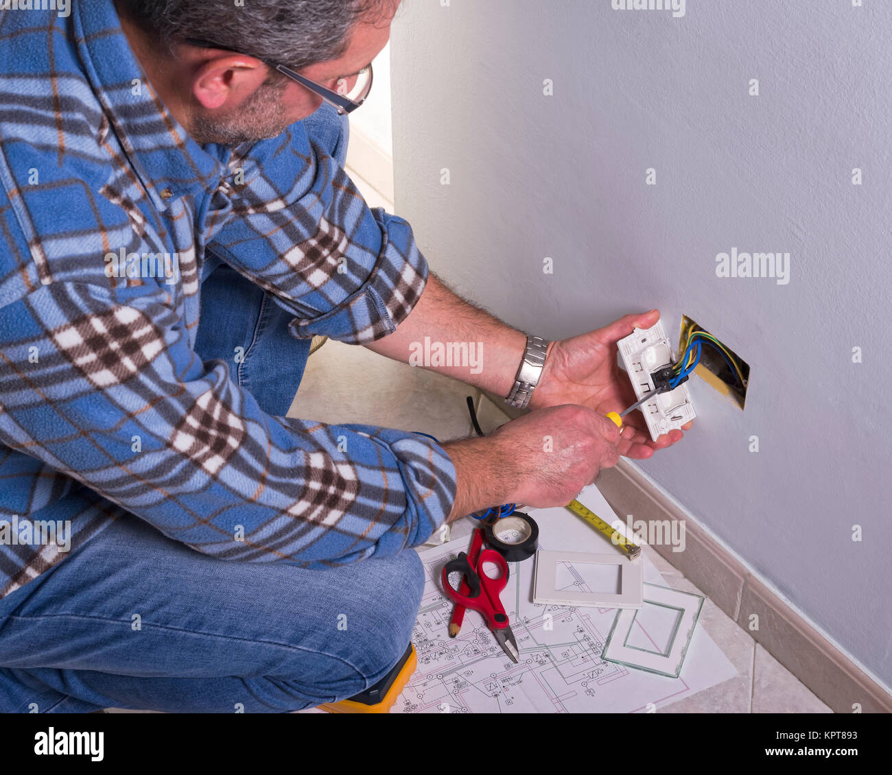 Per elettricista mani assembla un bipolare standard di presa di corrente a muro. Foto Stock