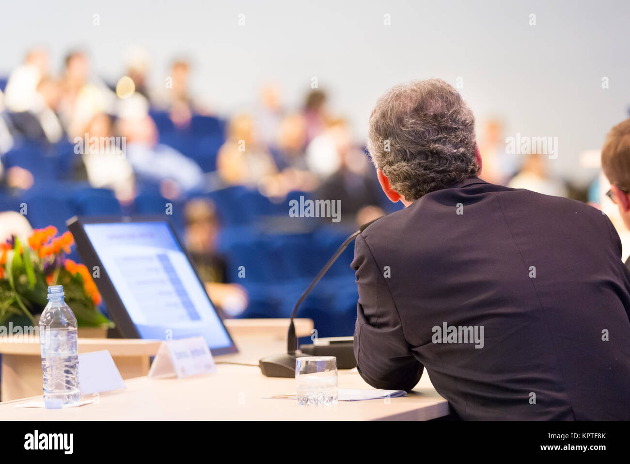 Come oratore a conferenze di affari con presentazioni pubbliche. Pubblico presso la sala conferenze. Club di imprenditorialità. Vista posteriore. Composizione Horisontal. Sfocatura dello sfondo. Foto Stock