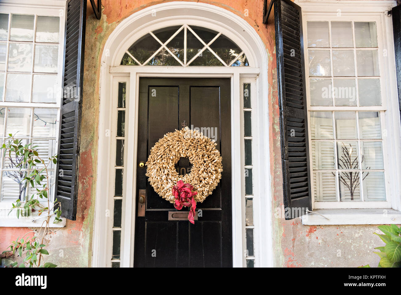 Una porta di legno di una storica casa decorata con una ghirlanda di Natale sulla strada incontro a Charleston, Sc. Foto Stock